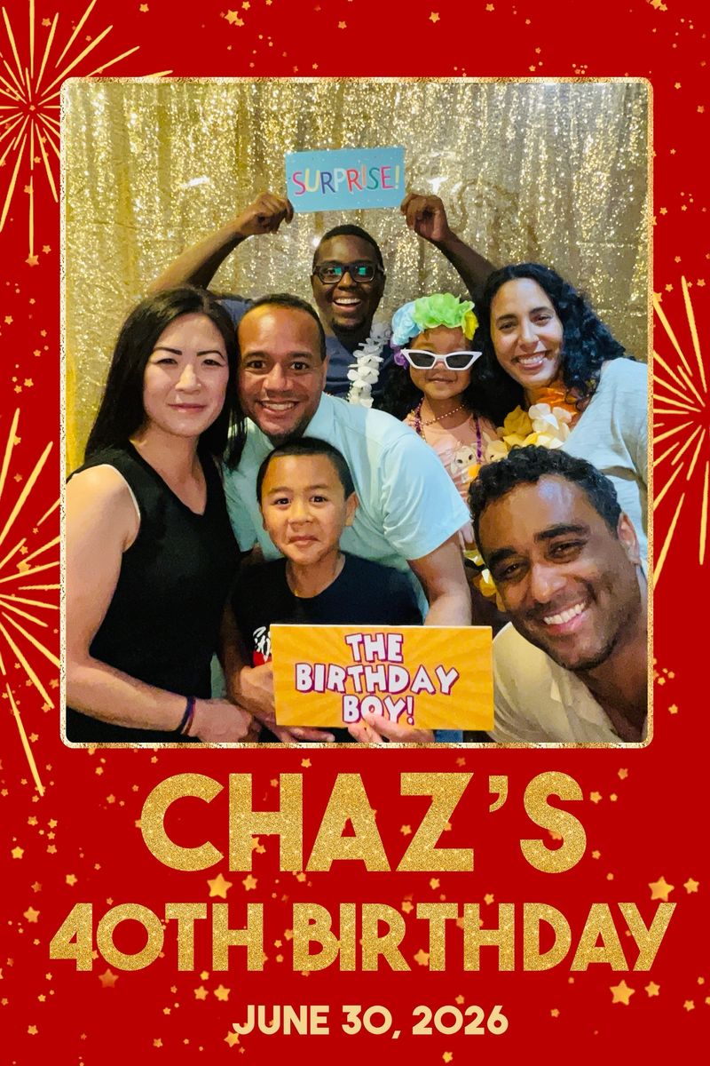 Friends and family crowd together holding Surprise and The Birthday Boy signs in front of a gold sequin backdrop, on a red fireworks-themed photo layout